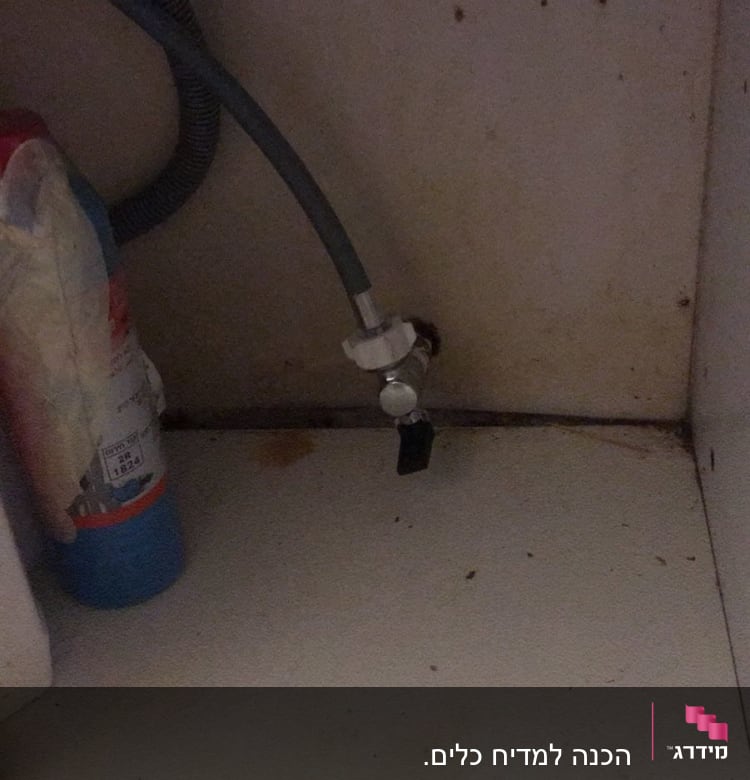 צינור מים וברז מתחת לכיור מטבח